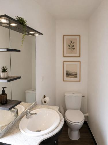 a white bathroom with a sink and a toilet at Studio Notre Dame in Château-Chinon