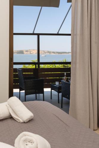 a bedroom with a bed and a view of the ocean at Nimaria Suites in Gialova