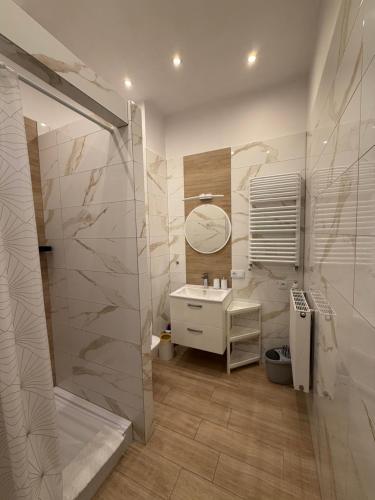 a bathroom with a shower and a sink and a mirror at Agroturystyka ''Dom Pod Karpiem'' in Zagórze Śląskie