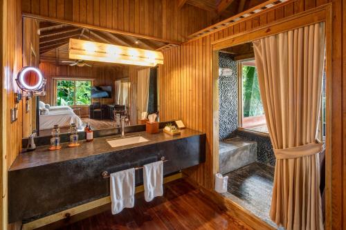 a bathroom with a sink and a bed in a room at Las Lagunas Boutique Hotel in Flores