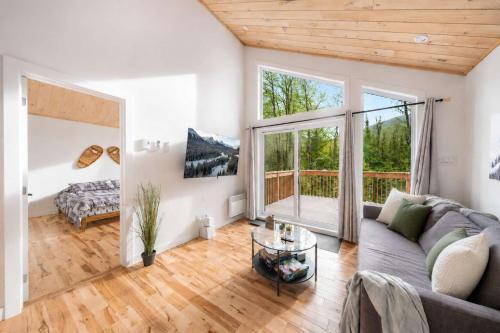 a living room with a couch and a large window at Spa & Foosball - Le WKD in Saint-Philémon