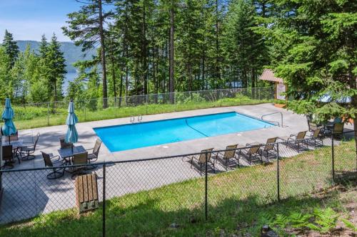 a swimming pool with chairs and a fence at Grizzly Den in Whitefish