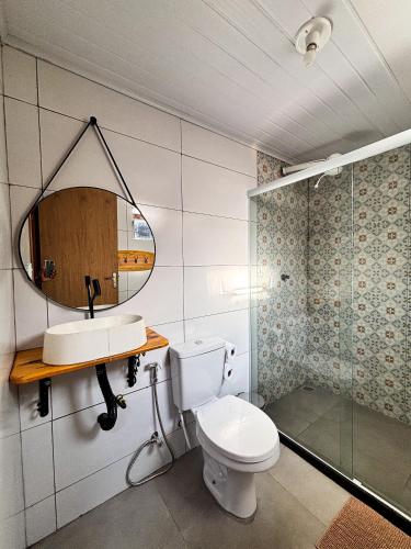 a bathroom with a toilet and a sink and a mirror at Ilha Grande Inn in Abraão