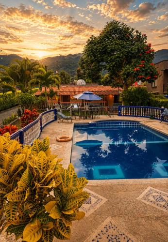 a swimming pool with a table and chairs and a house at Complejo Campestre Salome Cabañas & Hotel in Calima