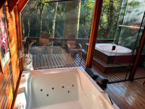 a bath tub in a room with a deck at Cabana Aracuã in Três Coroas