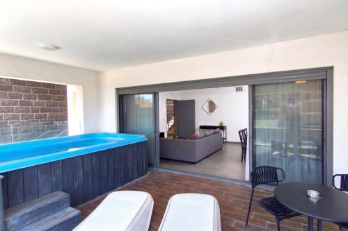 a swimming pool on a patio with a table and chairs at סי כנרת- דירות עם בריכה פרטית מבית בלו מגדל in Migdal