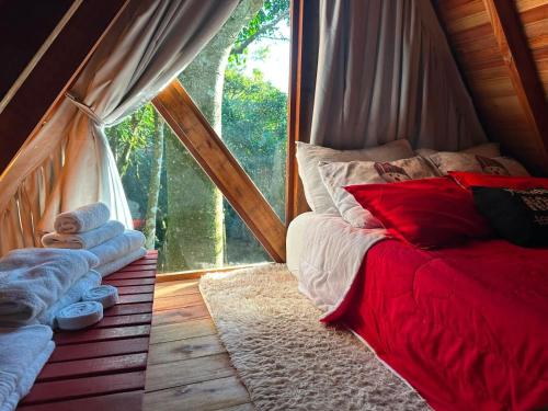 a bed in a room with a window and towels at Cabana Aracuã in Três Coroas