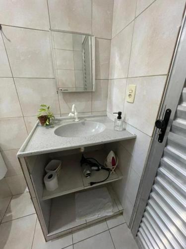 a bathroom with a sink and a mirror at JARDIM TROPICAL - QUARTO 03 ar-condicionado in Bayeux