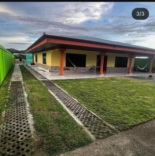 a yellow and green building with a grass yard at Hospedaje Lawson PJ in Palma