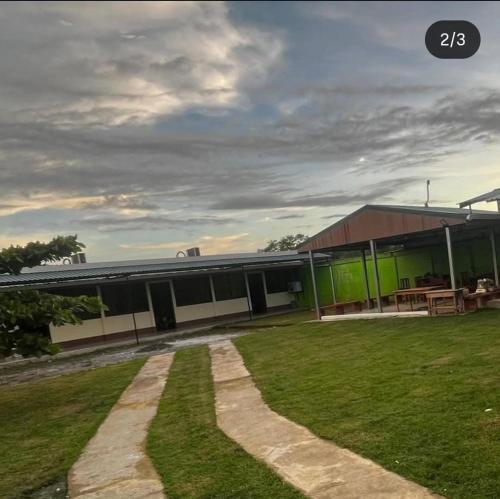 a building with a grassy yard in front of it at Hospedaje Lawson PJ in Palma