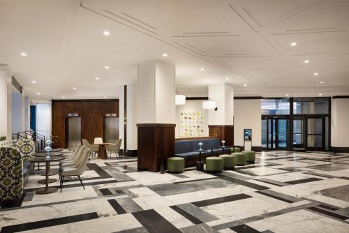 a lobby with a waiting area with chairs and tables at Hilton Boston Back Bay in Boston