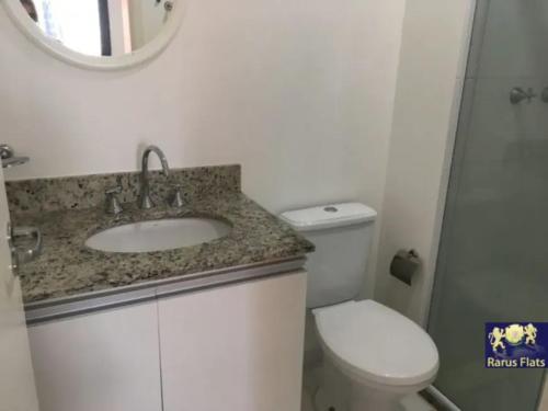 a bathroom with a sink and a toilet and a mirror at Apt 2019 in Paulínia