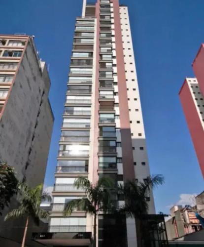 a tall building with palm trees in front of it at Apt 2019 in Paulínia