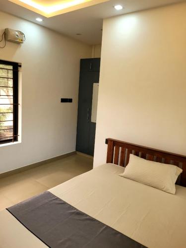 a bedroom with a bed and a green door at Hotel Grand Illam in Ernakulam