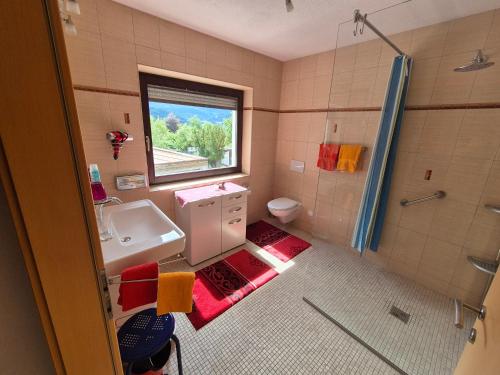 a bathroom with a sink and a toilet and a window at Appartement Simone Hofherr in Imst