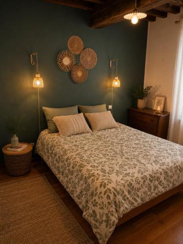 a bedroom with a large bed and two lights on the wall at La Longère de la Promenade in Château-Chinon