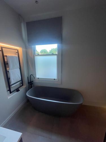 a bath tub in a bathroom with a window at Saint Peter Hotel in London