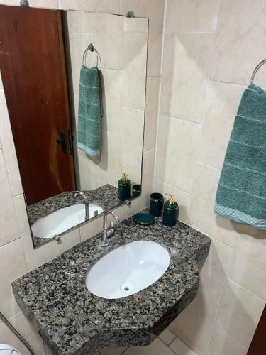 a bathroom with a sink and a mirror at Apartamento Central in Montes Claros
