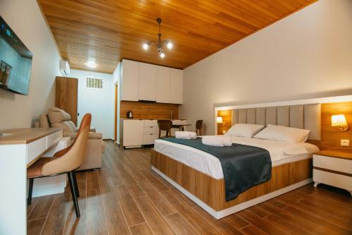 a bedroom with a large bed and a kitchen at Villa Mirakula Kvariati in Kvariati