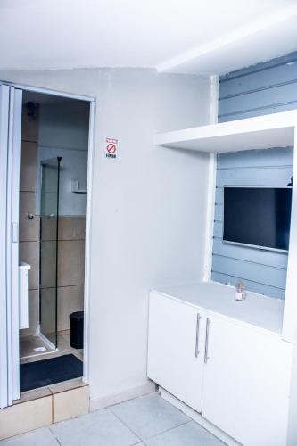 a white bathroom with a sink and a shower at pousada campolim prox ao hospital Bos in Sorocaba
