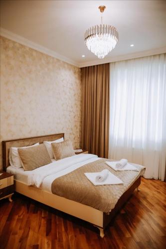 a bedroom with a large bed and a chandelier at Quba Garden Resort in Quba