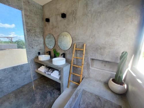 a bathroom with two sinks and a ladder and a cactus at Design Luxury Villa in Holbox Island