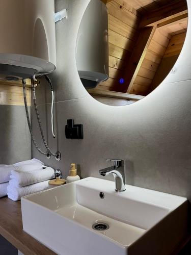 a bathroom with a white sink and a mirror at Djedina Gora Cabins in Poda