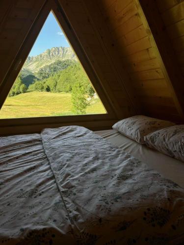 a bed in a room with a window at Djedina Gora Cabins in Poda