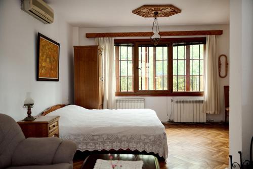 a bedroom with a bed and a large window at Family Hotel and Restaurant Varosha 2003 in Lovech
