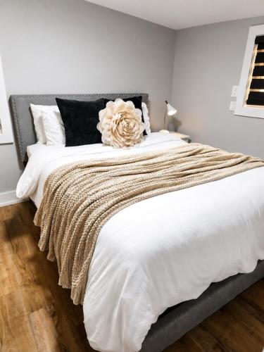 a bedroom with a large white bed with a flower on it at Modern 1 Bdrm with Laundry, BBQ, Deck in Welland
