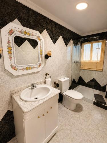 a bathroom with a sink and a toilet and a mirror at El Refugio de Leyla in Masía de Correntilla