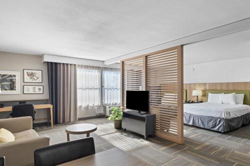 a hotel room with a bed and a tv at GreenTree Inn & Suites Phoenix Sky Harbor in Phoenix