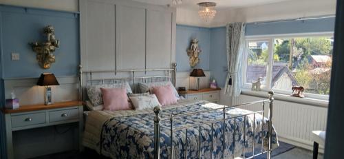 a bedroom with a bed with pink pillows and a window at Brunant Arms Hotel in Caio