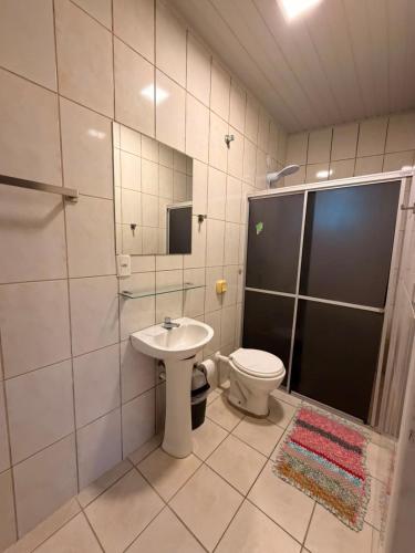 a bathroom with a toilet and a sink and a shower at Apto centro 03 in Tubarão