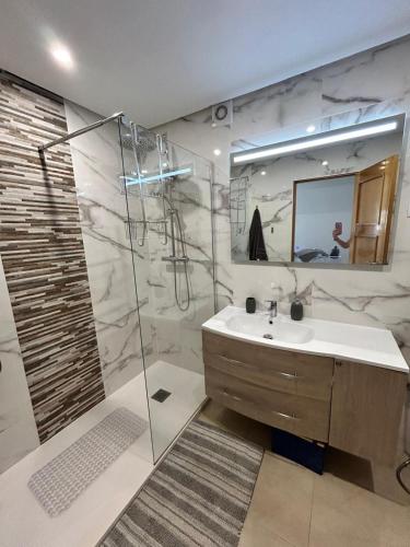 a bathroom with a sink and a shower with a mirror at Casa Emperador Penthouse in Roldán