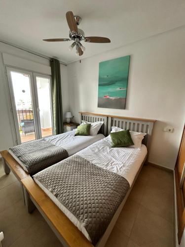 a bedroom with two beds and a ceiling fan at Casa Emperador Penthouse in Roldán