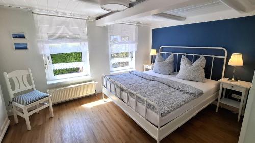 a bedroom with a white bed and a blue wall at Ferienwohnung Alte Schmiede in Wangerland