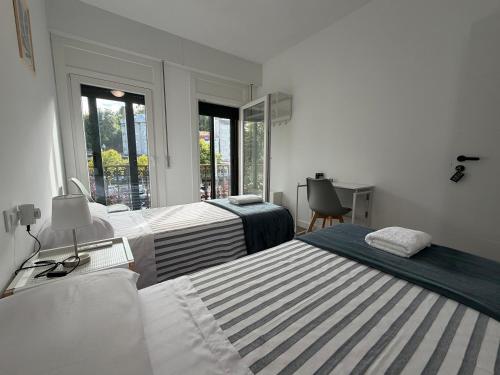 a bedroom with two beds and a desk and window at Rubín 21 in Redondela