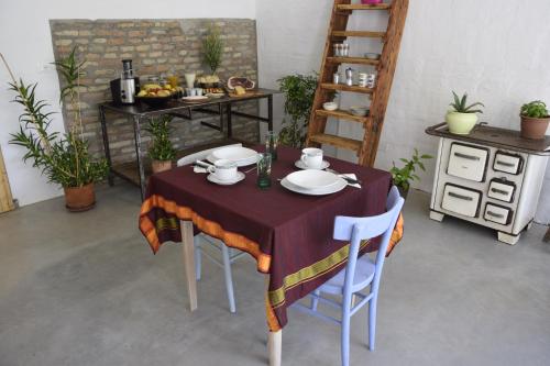 a table with a purple table cloth and white plates at Capannone111 in Castiglione di Ravenna
