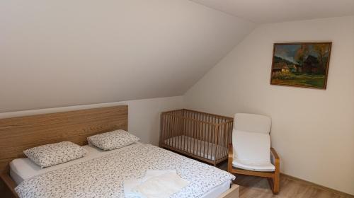a small bedroom with a bed and a chair at Rekreačné domy pod Vlkolíncom in Ružomberok
