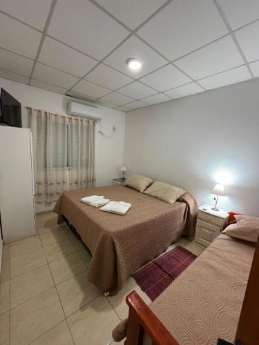 a bedroom with two beds and a television in it at Jade in Chajarí