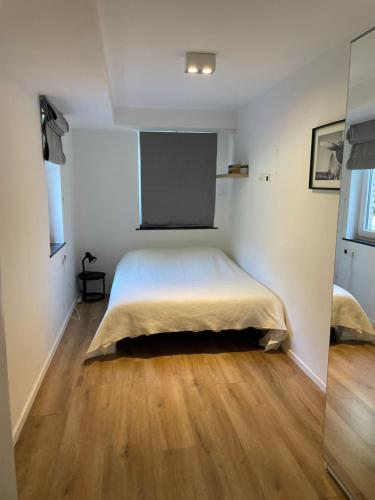 ein Schlafzimmer mit einem Bett und einem Holzboden in der Unterkunft Hoeilaart in Hoeilaart