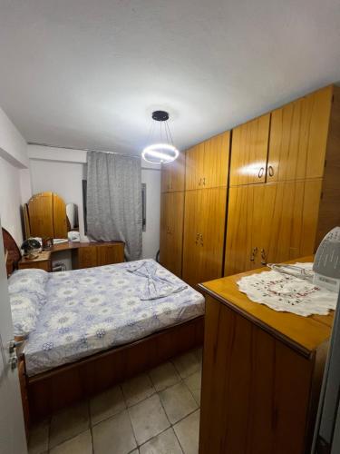 a bedroom with a bed and wooden cabinets at Apartament 33 in Elbasan