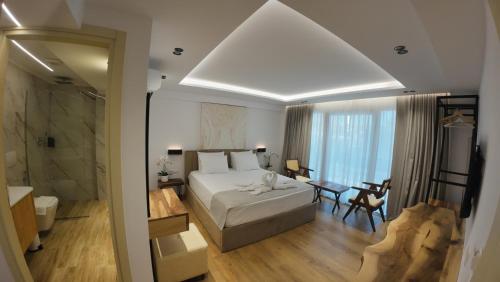 a bedroom with a large bed and a bathroom at Vila Kosteli in Himare