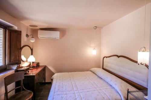 モンテ・アルジェンターリオにあるCasalino Spagnolo Cozy Apartmentのベッドルーム(ベッド1台、テーブル、鏡付)