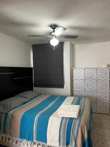 a bedroom with a bed with a ceiling fan at Casa Múkara del Puerto in Veracruz