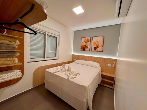 a small room with a bed and a window at Yolanda Flats in Foz do Iguaçu