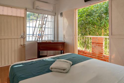 a bedroom with a bed and a window and a desk at Casa Blanca in Santa Marta