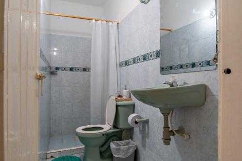 a bathroom with a green toilet and a sink at Casa Blanca in Santa Marta