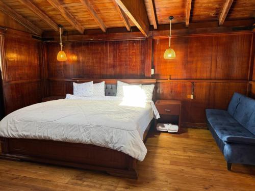 a bedroom with a bed and a blue couch at Mount House Lodge in Guano
